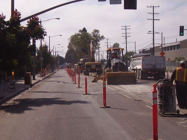 Pipeline removal work zone on a city street with traffic control and equipment